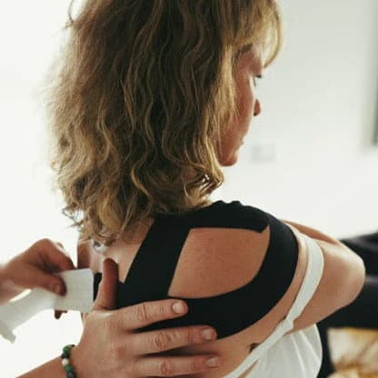Kinesio tape being applied for injury rehabilitation and posture correction